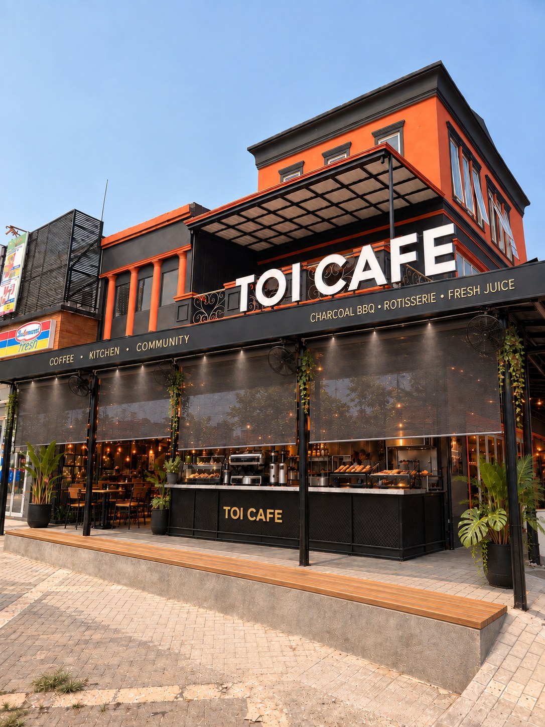 Tampak depan TOI Café dengan fasad oranye dan area BBQ